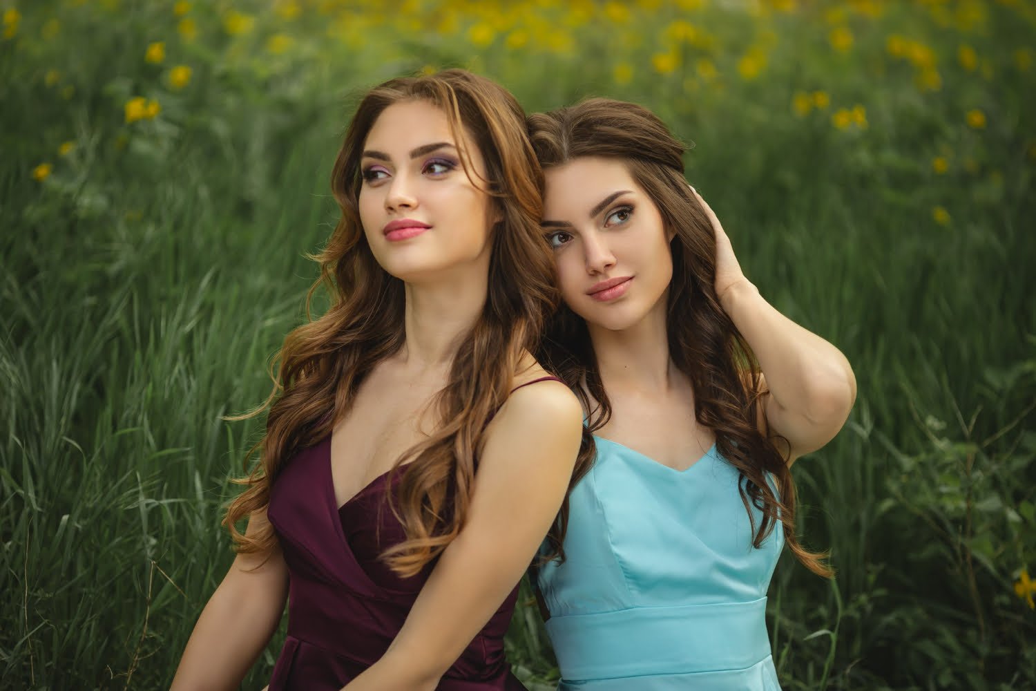 fashionable twins models with perfect make up hairstyle sitting green grass